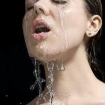 Water splashes on woman's face